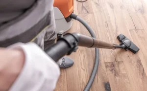 Person vacuming hardwood floor